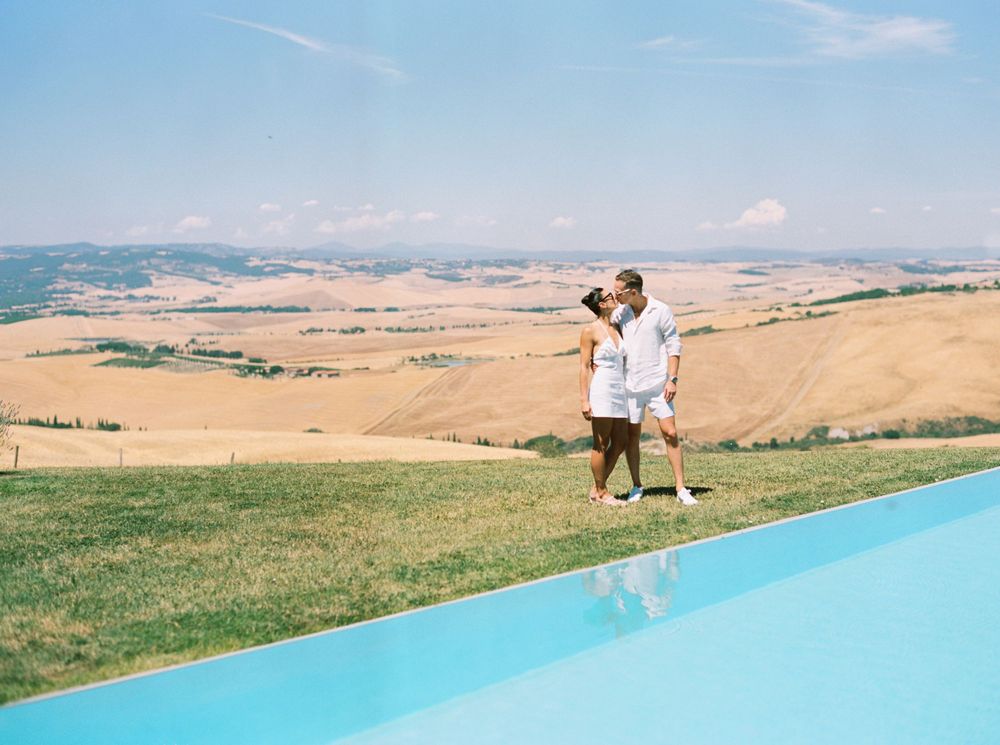 A bride and groom at a white wedding pool party at La Bandita Countryhouse, Tuscany, Italy.