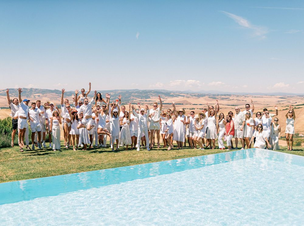 White-clad guests at a white wedding pool party in Tuscany, Italy.
