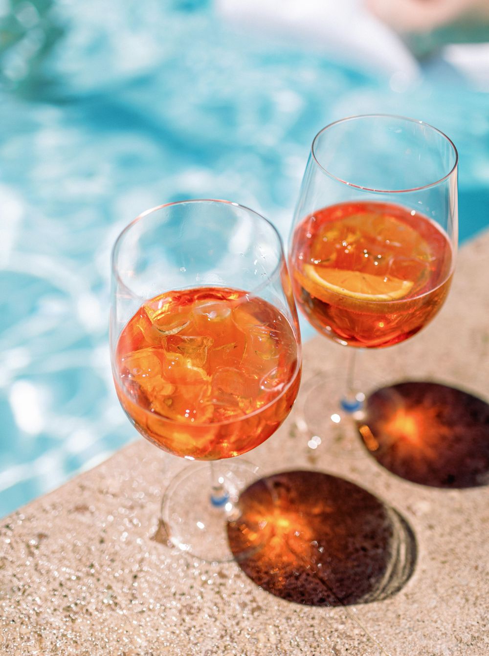 Two glasses of orange drink at a wedding pool party in Tuscany, Italy.