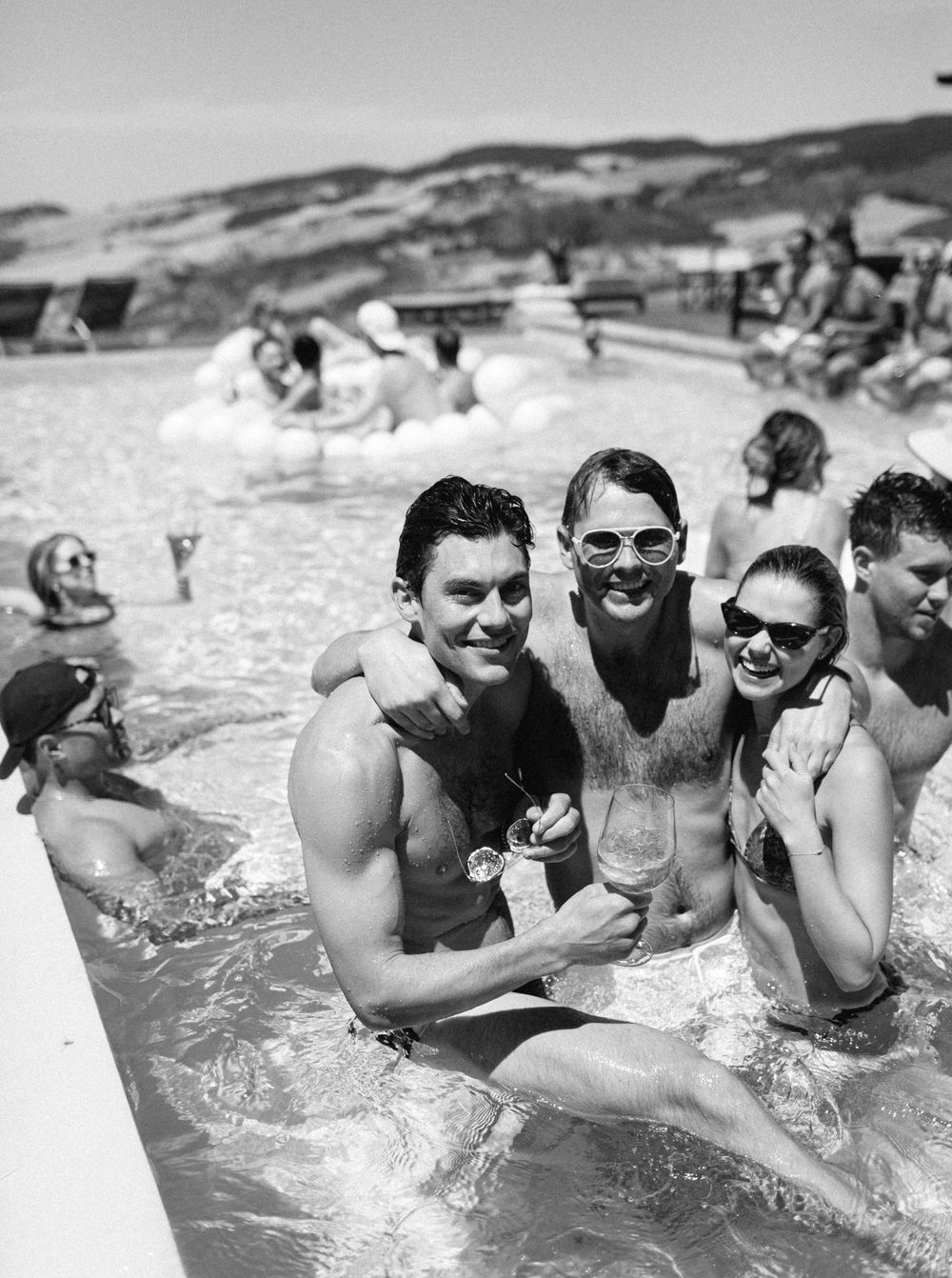 Pool scene with people in black and white at a Tuscany wedding event.