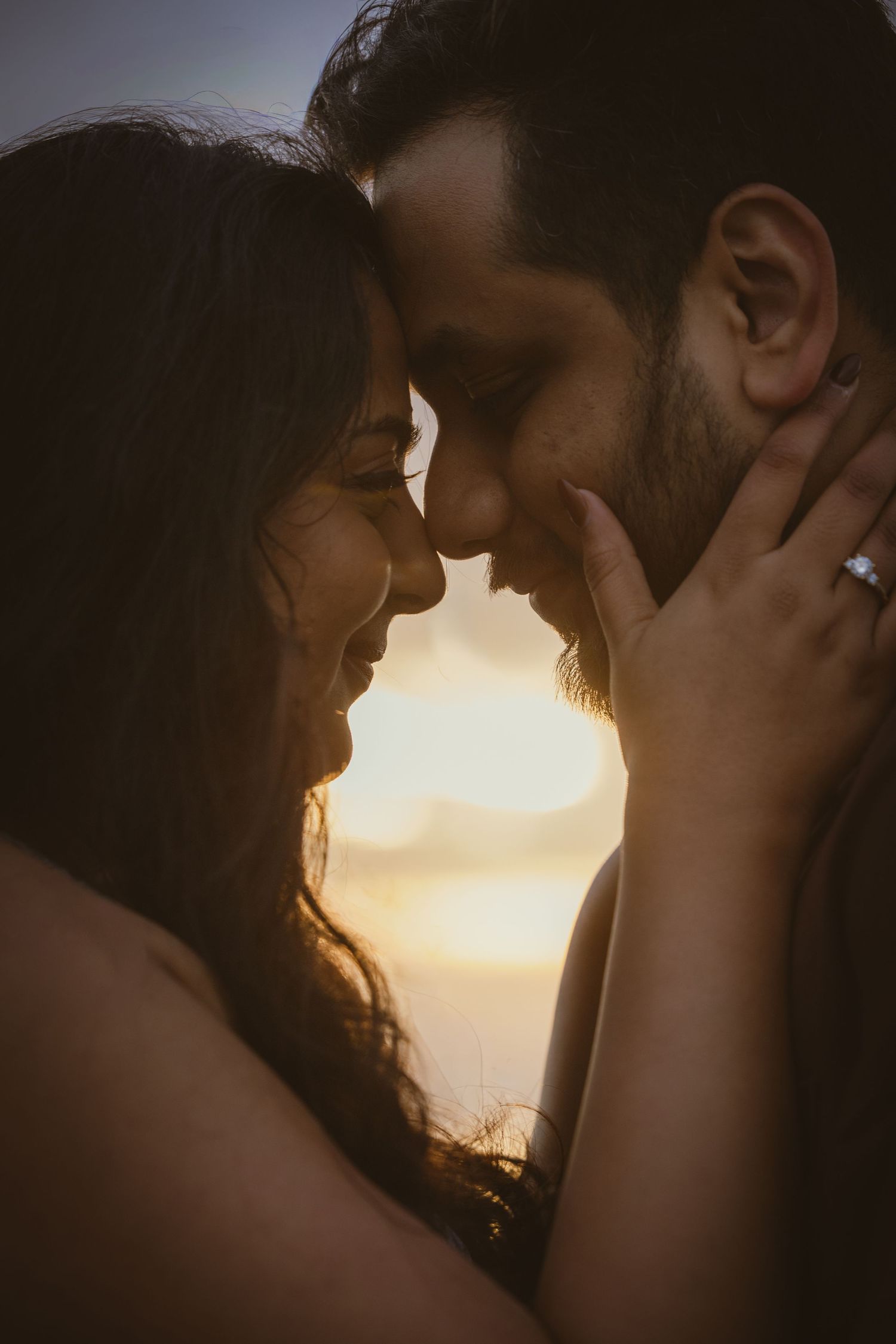 Photo of couple sharing romantic kiss in front of scenic waterfall taken by PNW engagement photographer.