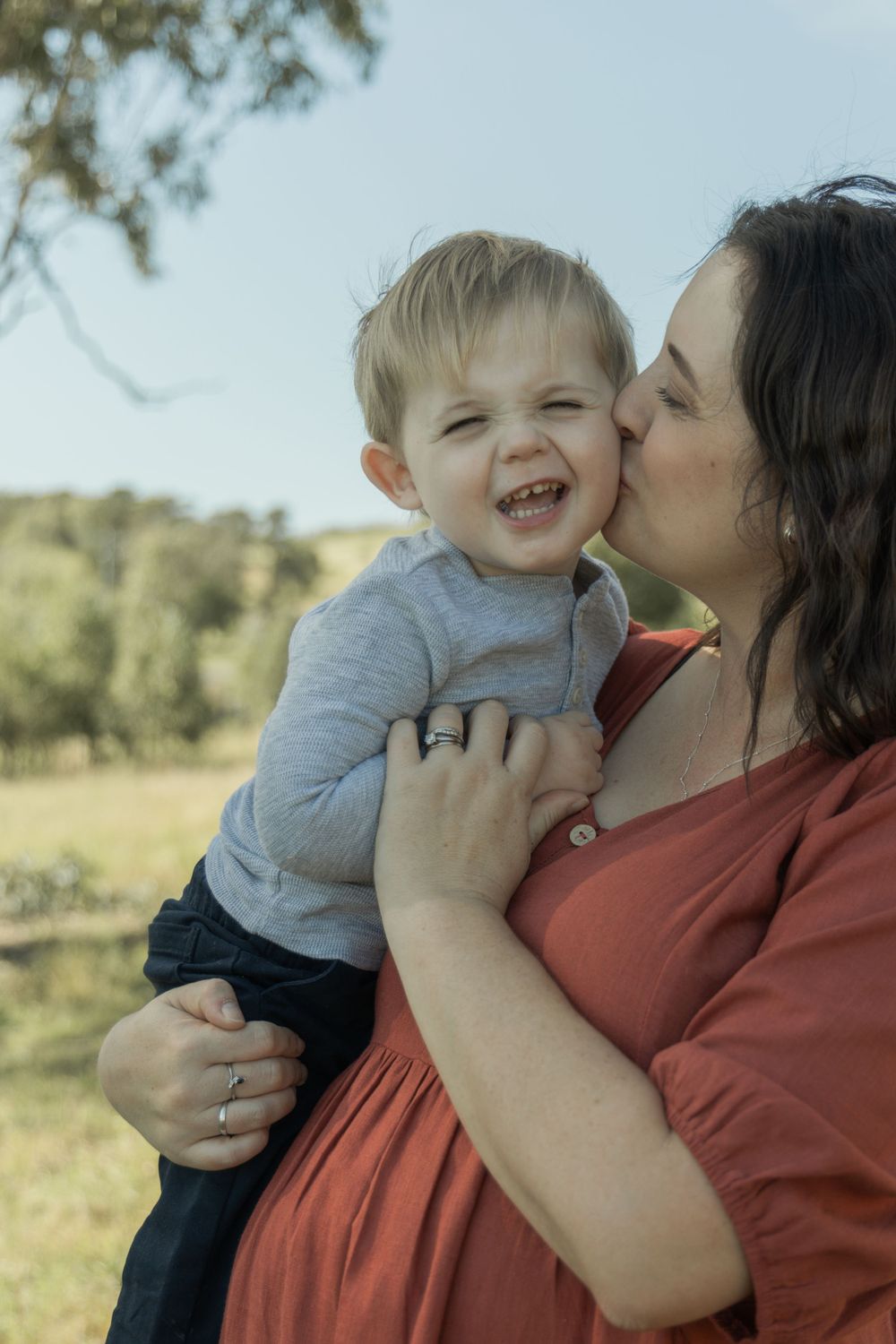 A joyful moment captured between parent and child outdoors in natural lighting.