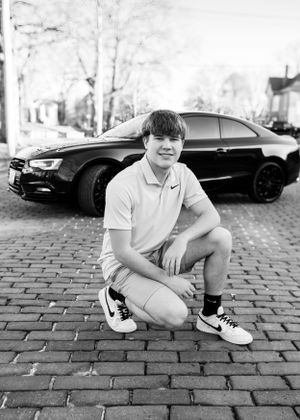 Senior photo with an Audi car in Boonville, MO, showcasing style and personality in a dynamic, scenic setting.