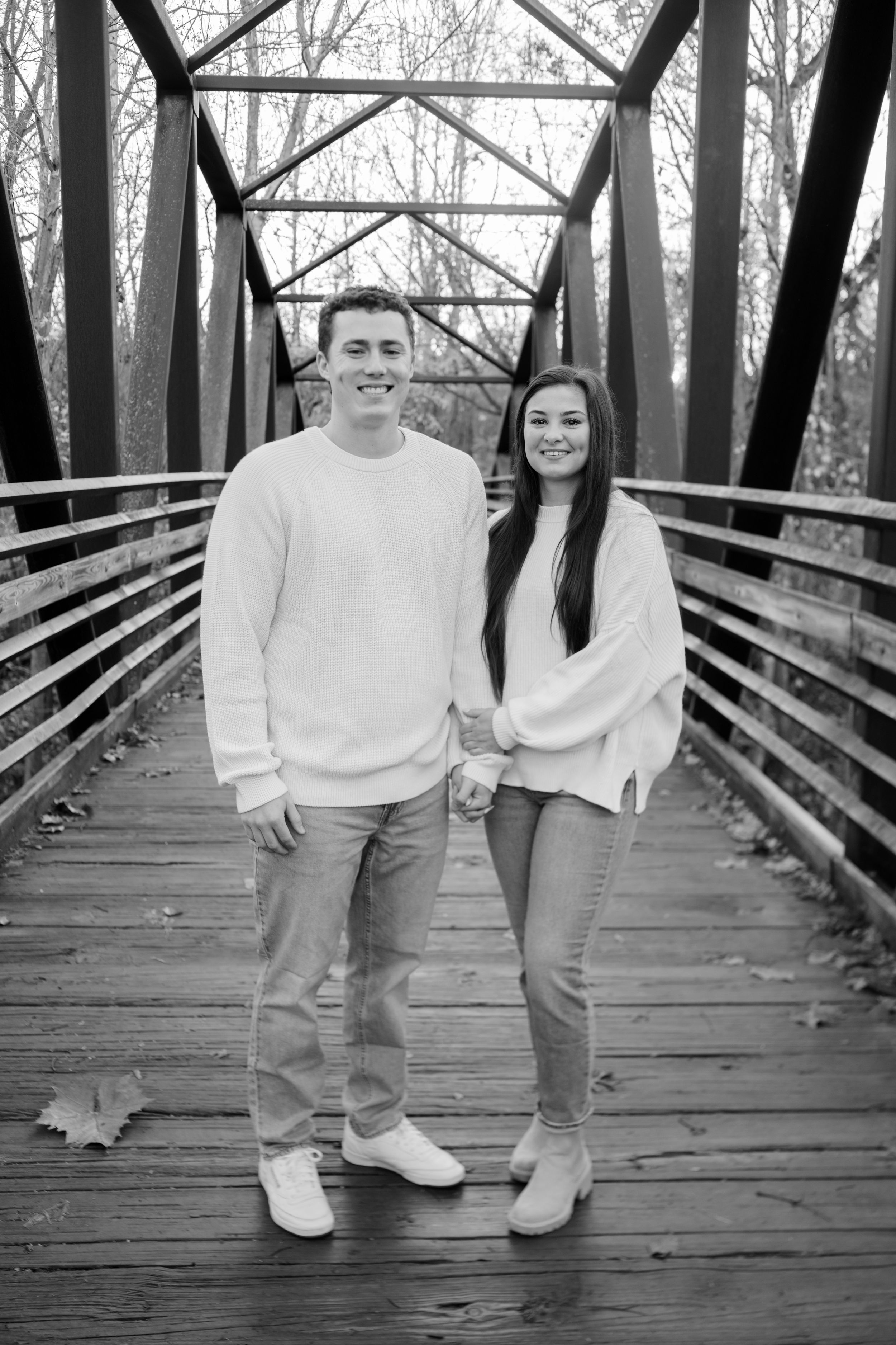 Romantic couples photo shoot on a bridge, capturing intimate moments and connection in a scenic setting.