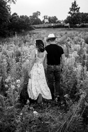 Couples photo shoot in a picturesque flower field, capturing romantic moments of clients holding hands in a serene setting.