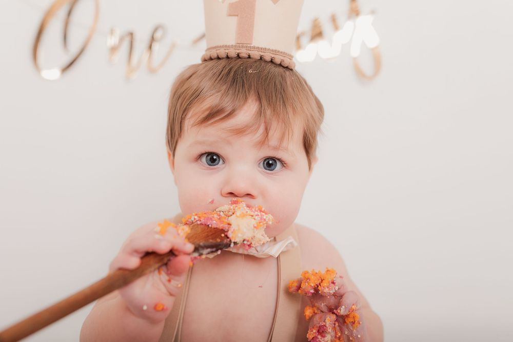 Baby enjoying cake smash photo session with pink frosting. Photographer. Hull. East Yorkshire. Photography