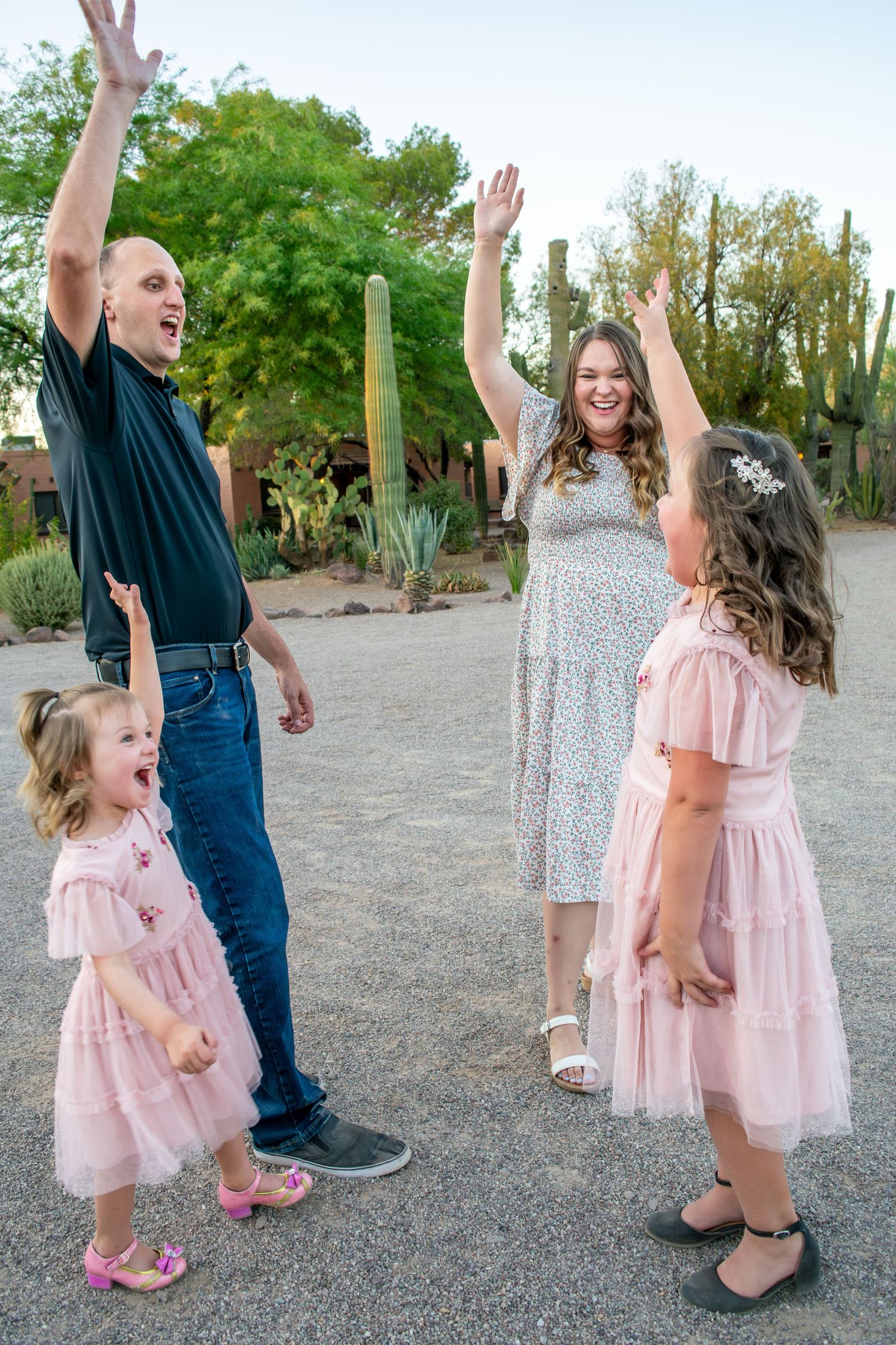 a mom and daughter dressed up for family pictures and laughing at the camera