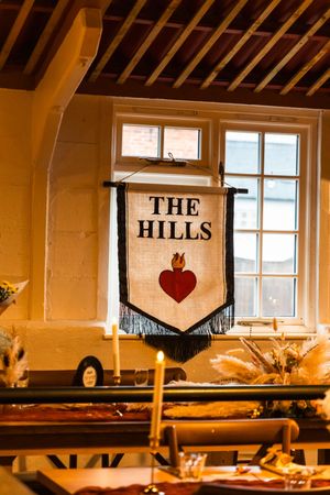 Rustic wedding venue interior with hanging banners and warm lighting creates cozy ambiance.