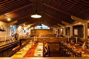 Panoramic view of an industrial-style event space with exposed beams and natural lighting.