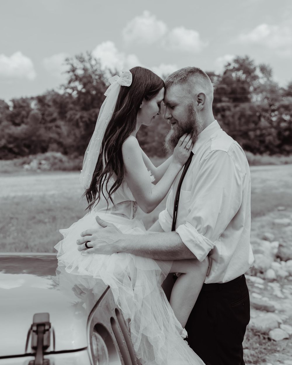 Black and white romantic portrait captured in an outdoor setting.
