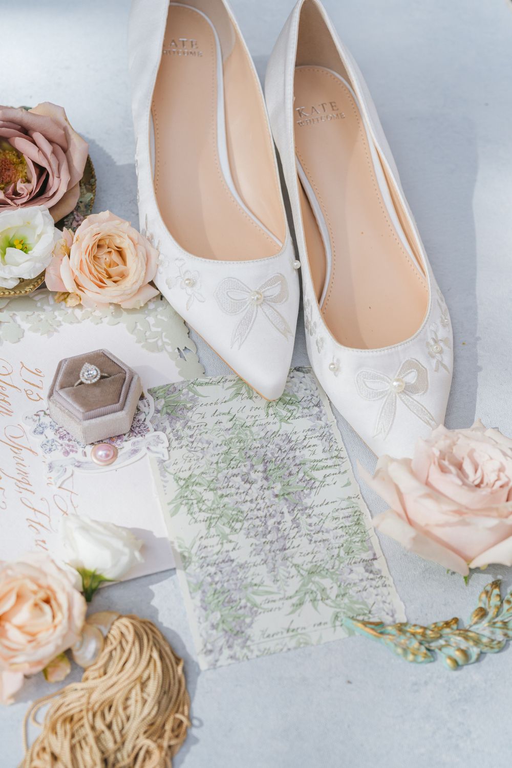 White bridal shoes styled with handwritten vows and blush roses.