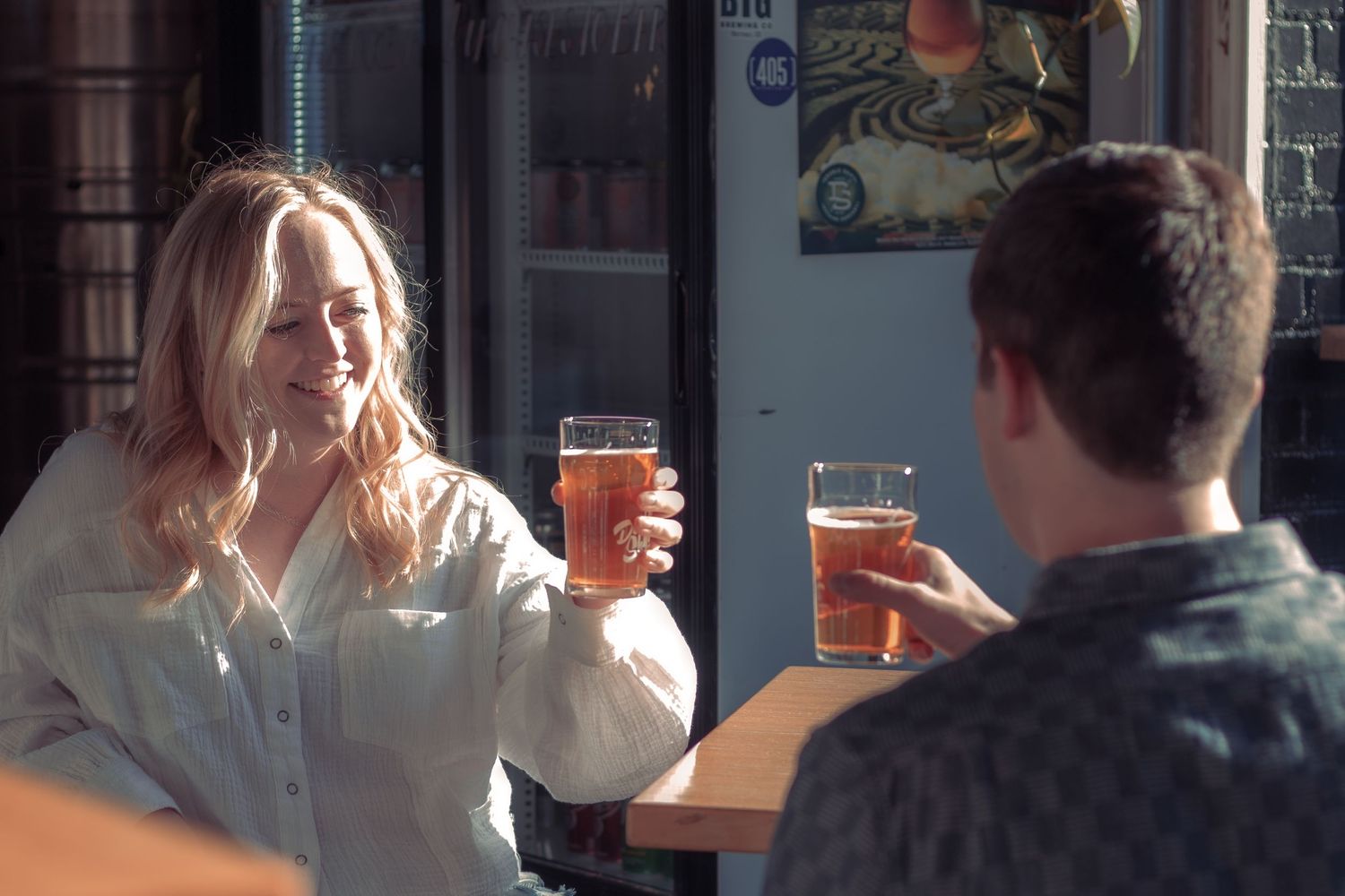 People enjoying drinks at a dimly lit bar or pub setting.