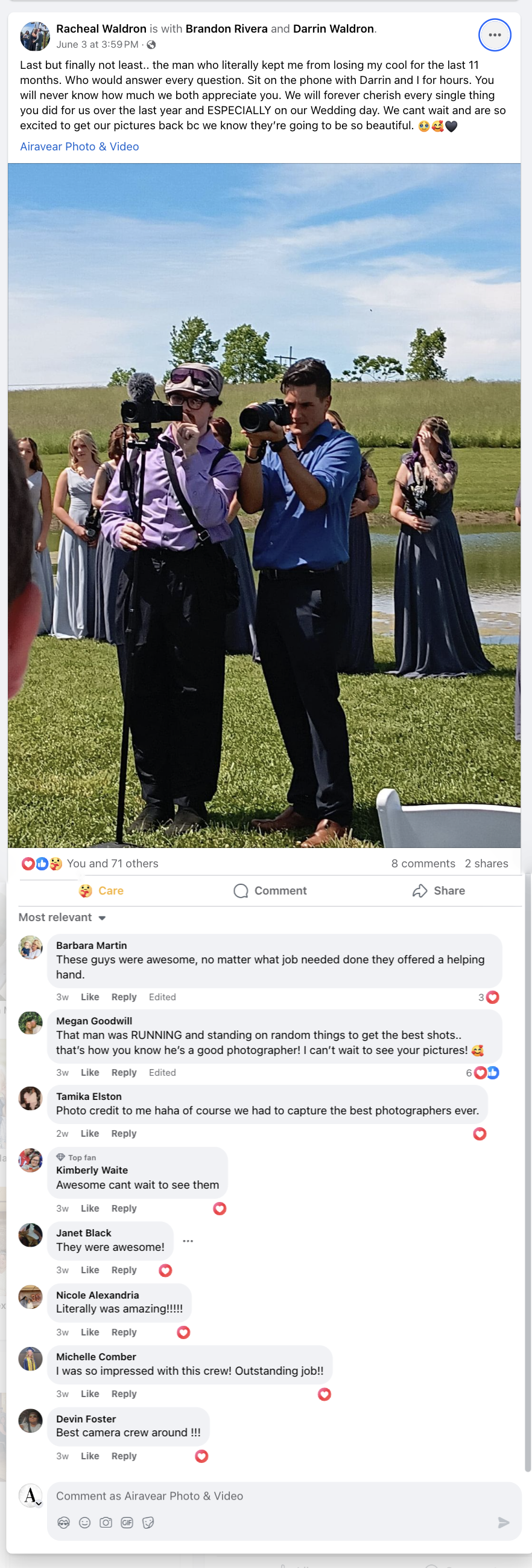 Two photographers capturing an outdoor event near a lake with bridesmaids in grey dresses in the background.