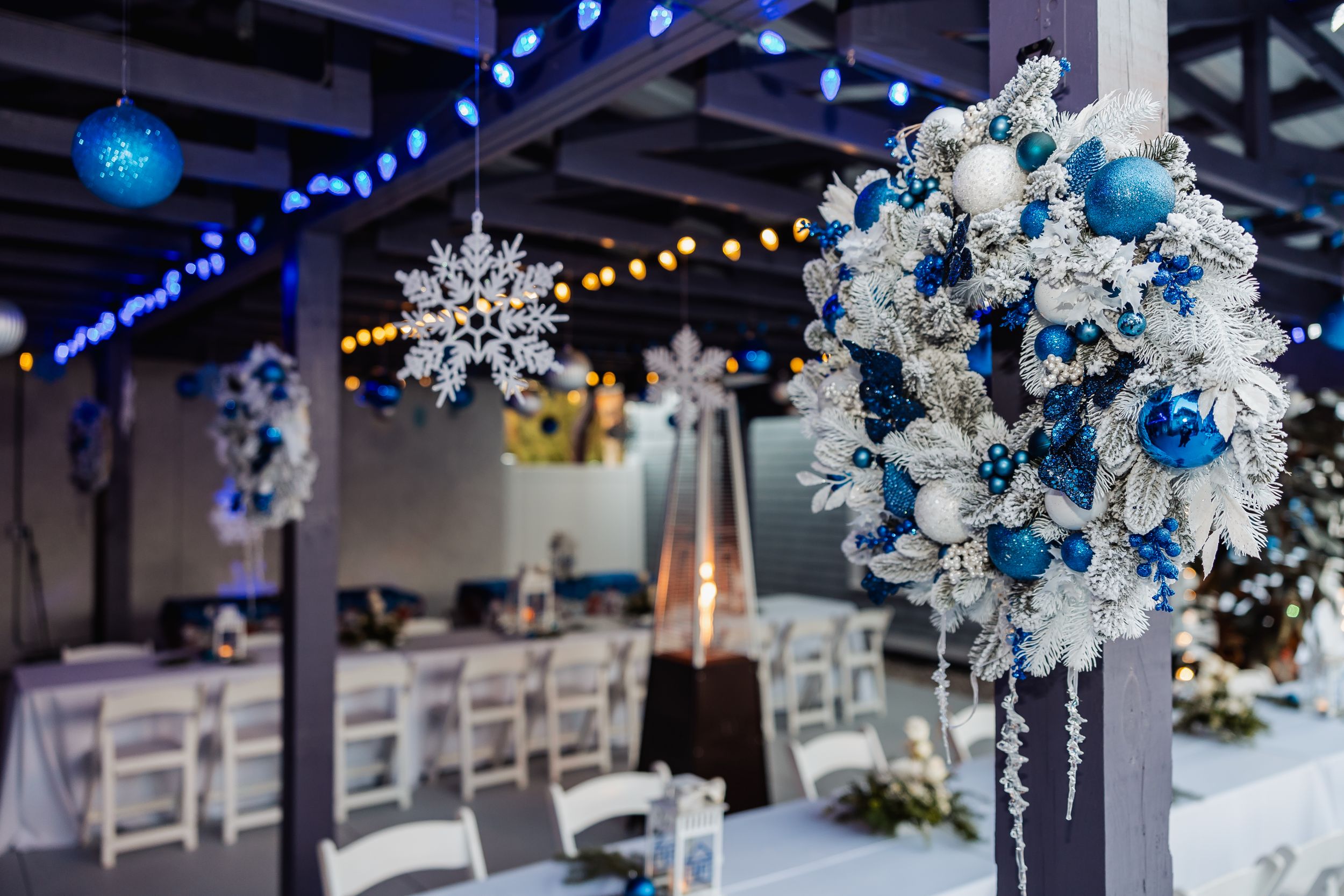Blue and white winter themed floral arrangement with snowflake decorations.