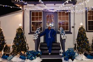 Festive outdoor display with decorated Christmas trees and blue ornaments at night.