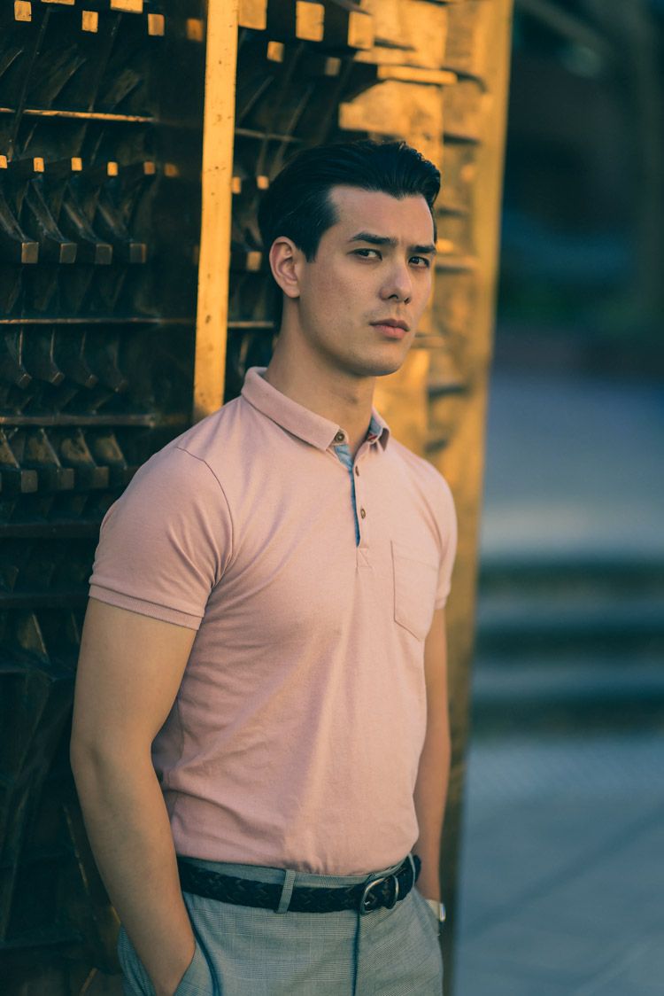 Portrait image of a man wearing a pink shirt and gray pants. By Nick Wigmore Photography.