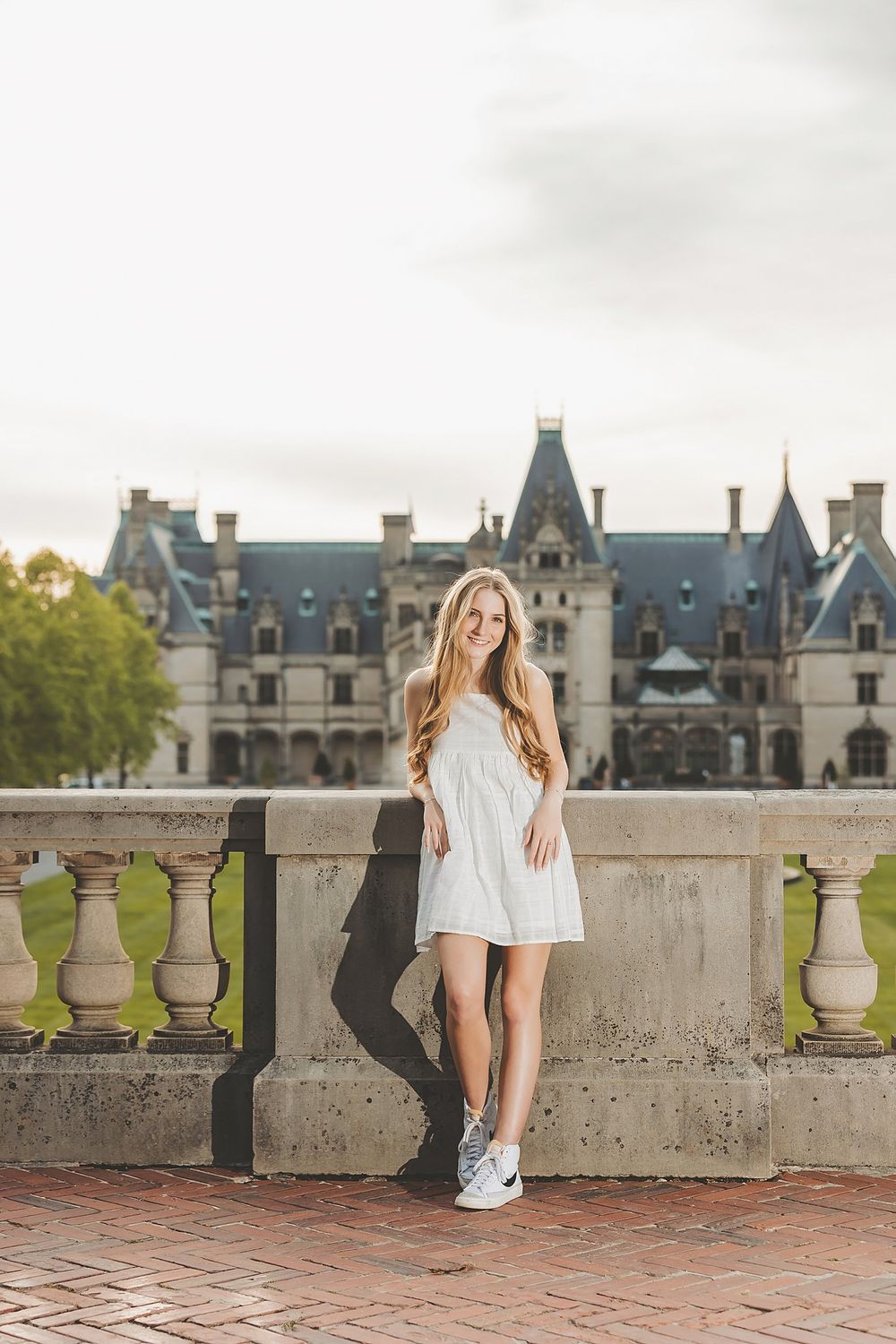Scenic portrait at Biltmore Estate with castle architecture and stone balustrade in background.