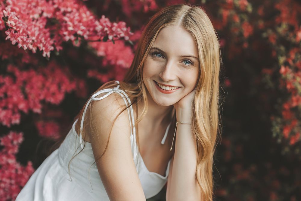Natural light portrait with red autumn foliage creating dramatic contrast.