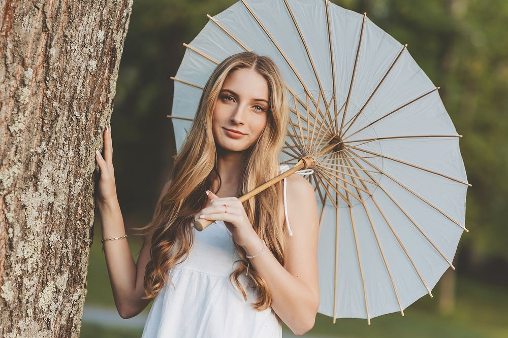 Outdoor portrait sequence with decorative white parasol against natural backdrop.