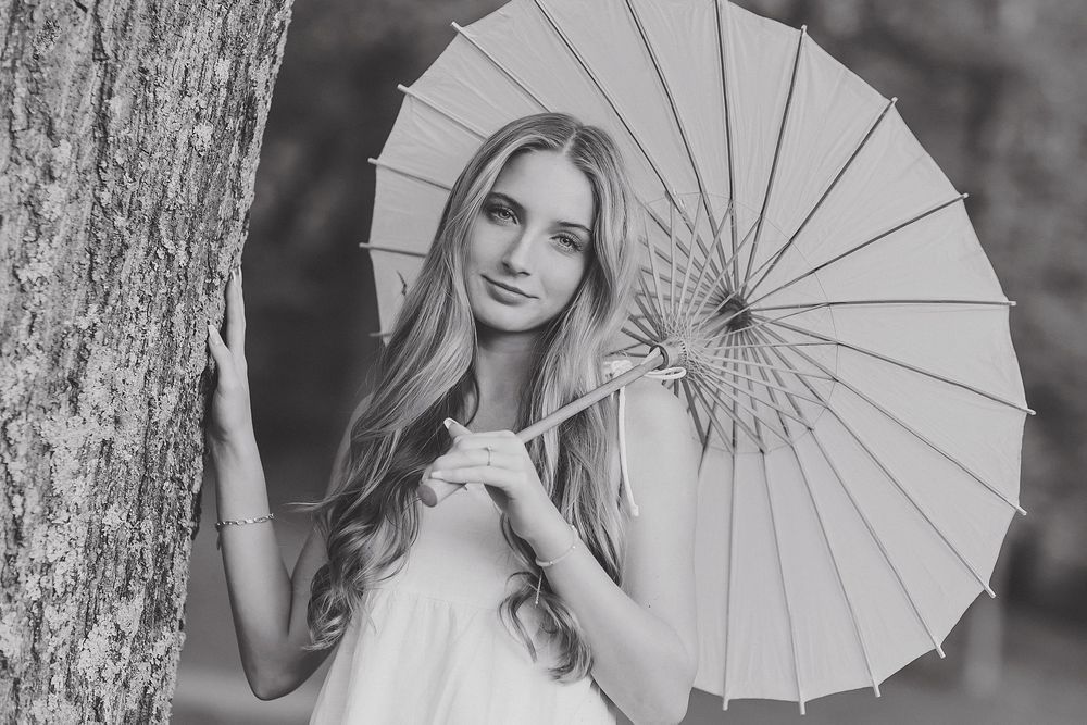 Black and white portrait series featuring elegant white parasol and tree backdrop.