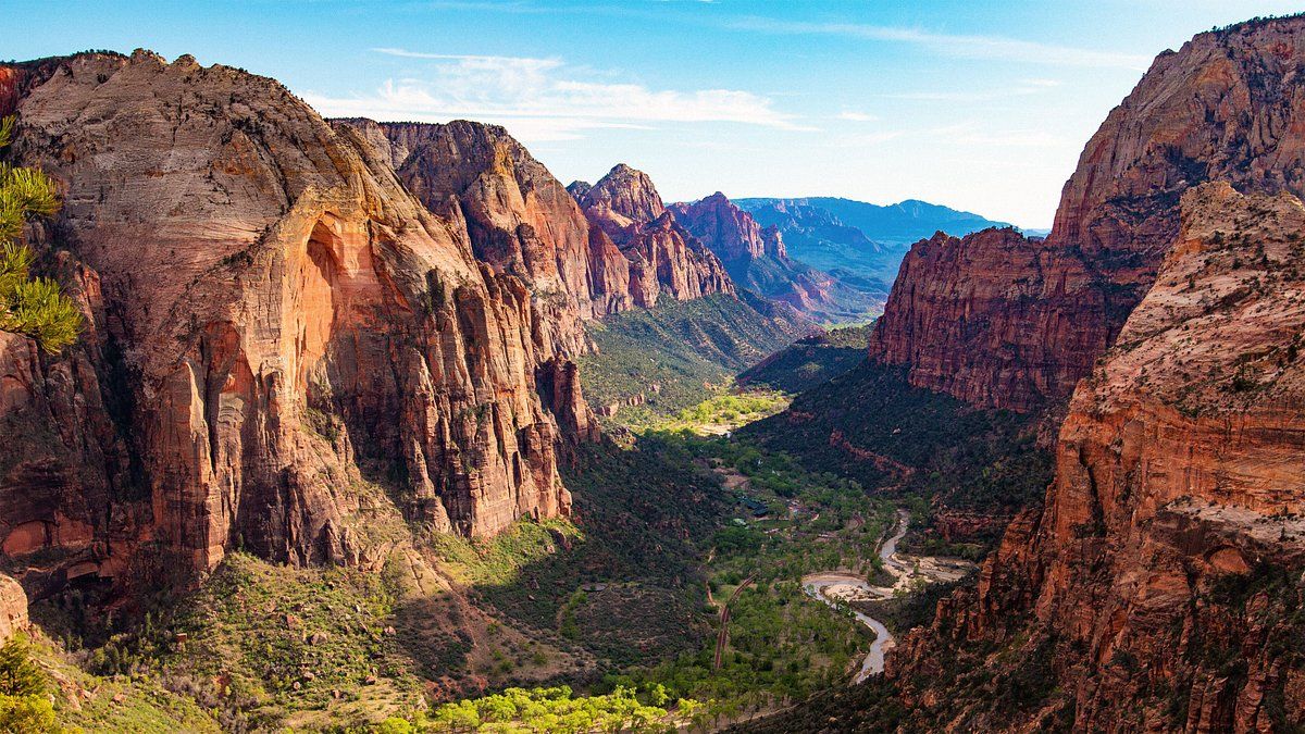 Panoramic view of Zion Canyon with red rock cliffs and lush green valley in Zion National Park, Utah.