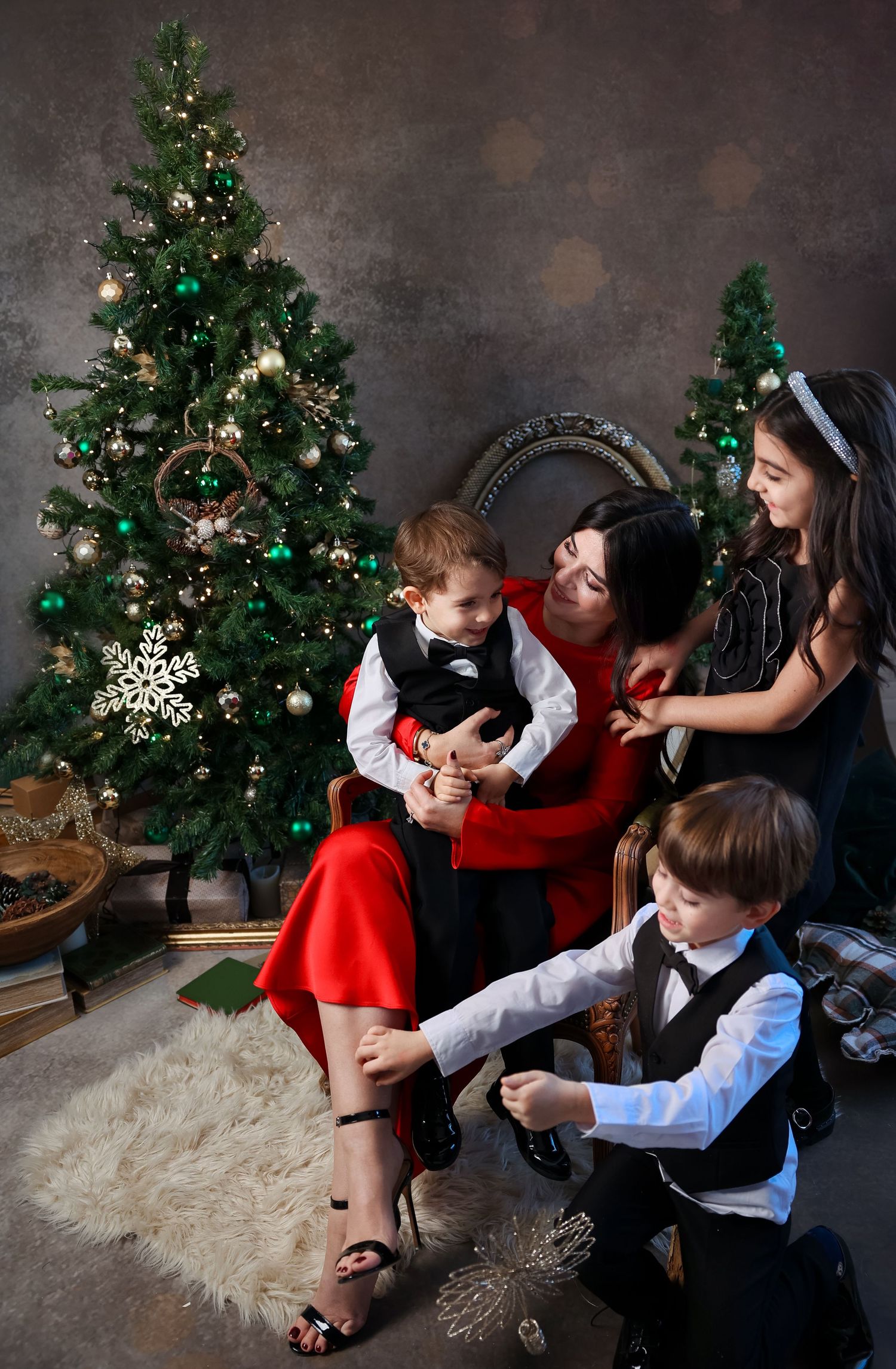 Family gathered around decorated Christmas tree in cozy holiday setting.