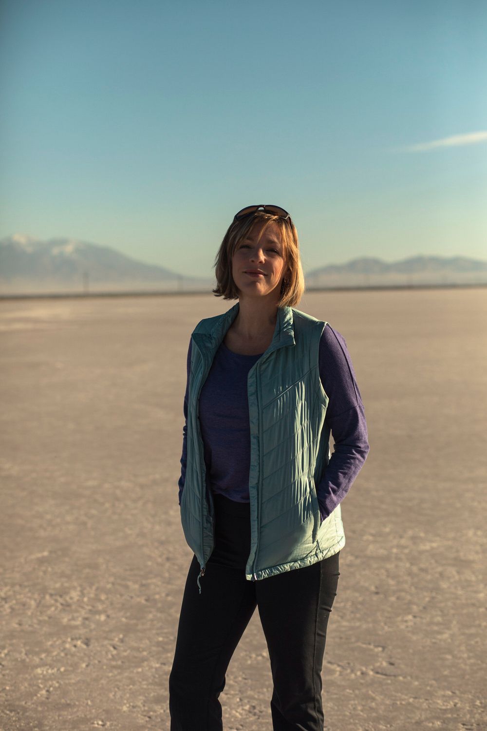 Alison of Lumenali Photography stands happily on the salt flats in Salt Lake City, Utah.