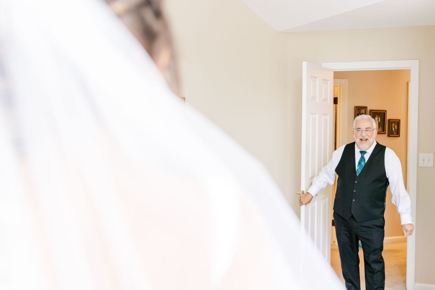 Emotional first look moment through doorway on wedding day.