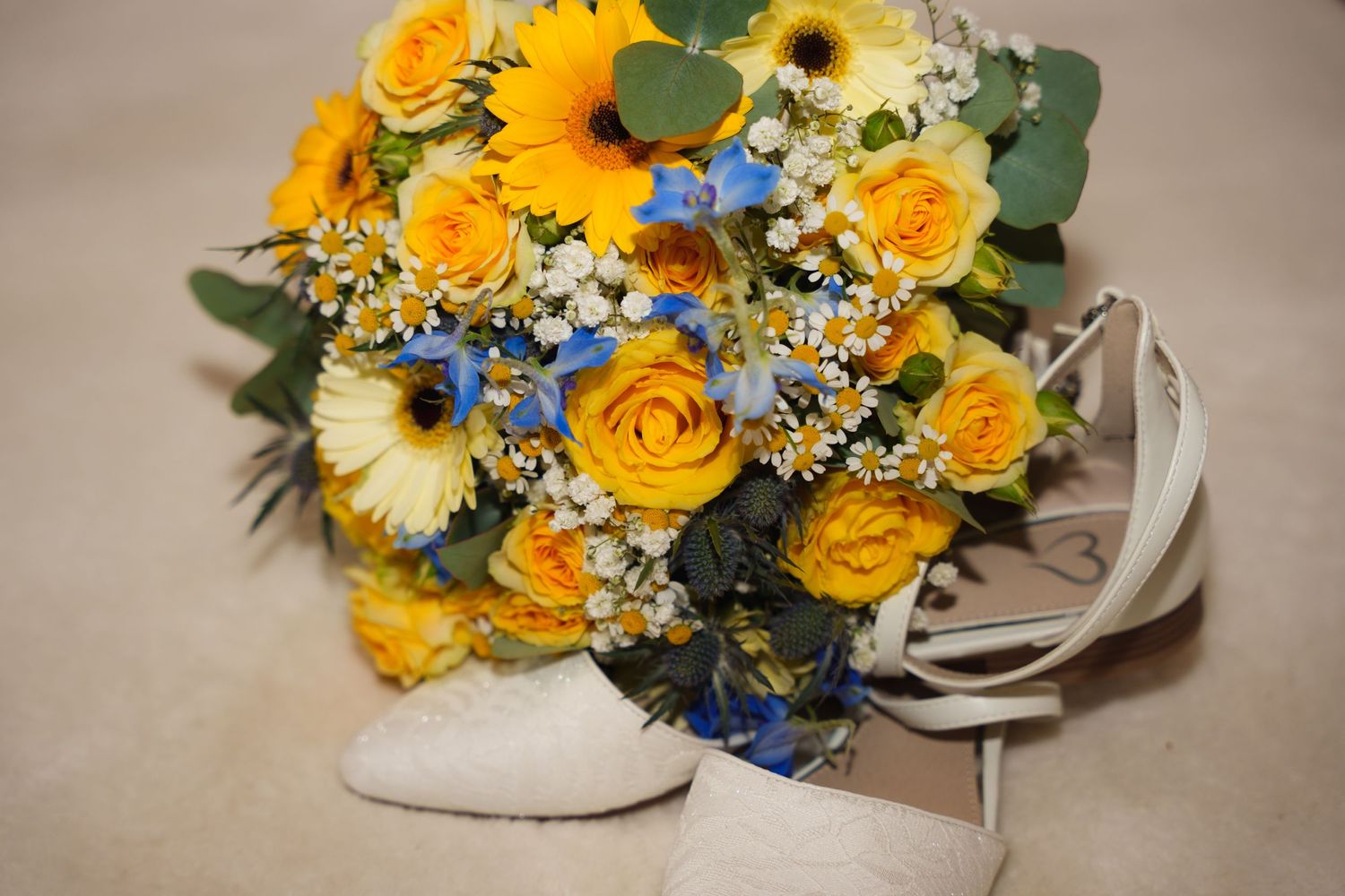 Yellow and blue wedding bouquet featuring roses, gerbera daisies and delicate wildflowers.