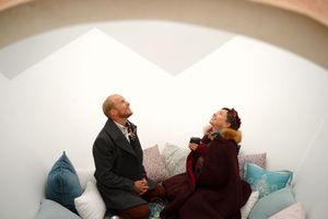 People engaging in partner exercises during a wellness workshop in a bright white space.
