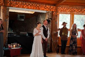 Celebration in a rustic venue with string lights and wood paneling.