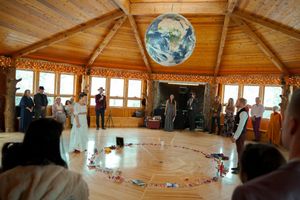 Wide angle view of a circular workshop setup in a wooden lodge with natural lighting.