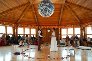 Panoramic view of a wedding venue with wooden ceiling beams and decorative white draping.
