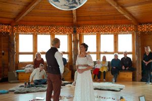 A rustic wedding reception space with wooden architecture and ambient lighting.