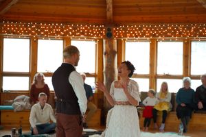 Group wellness session in progress inside a rustic timber-framed space with large windows.