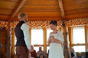 Wedding party celebrating in a warm wooden interior with string lights and hanging paper lanterns.