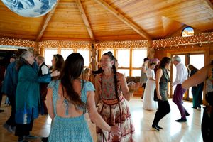 People dancing in a rustic wooden room during a traditional social dance event.
