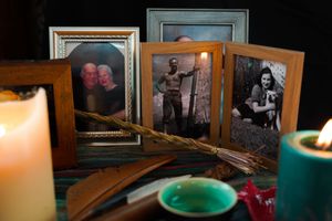 Dimly lit display of vintage framed photographs with candles creating an intimate atmosphere.