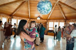 Festive celebration in a wooden lodge with hanging paper lanterns and string light decorations.
