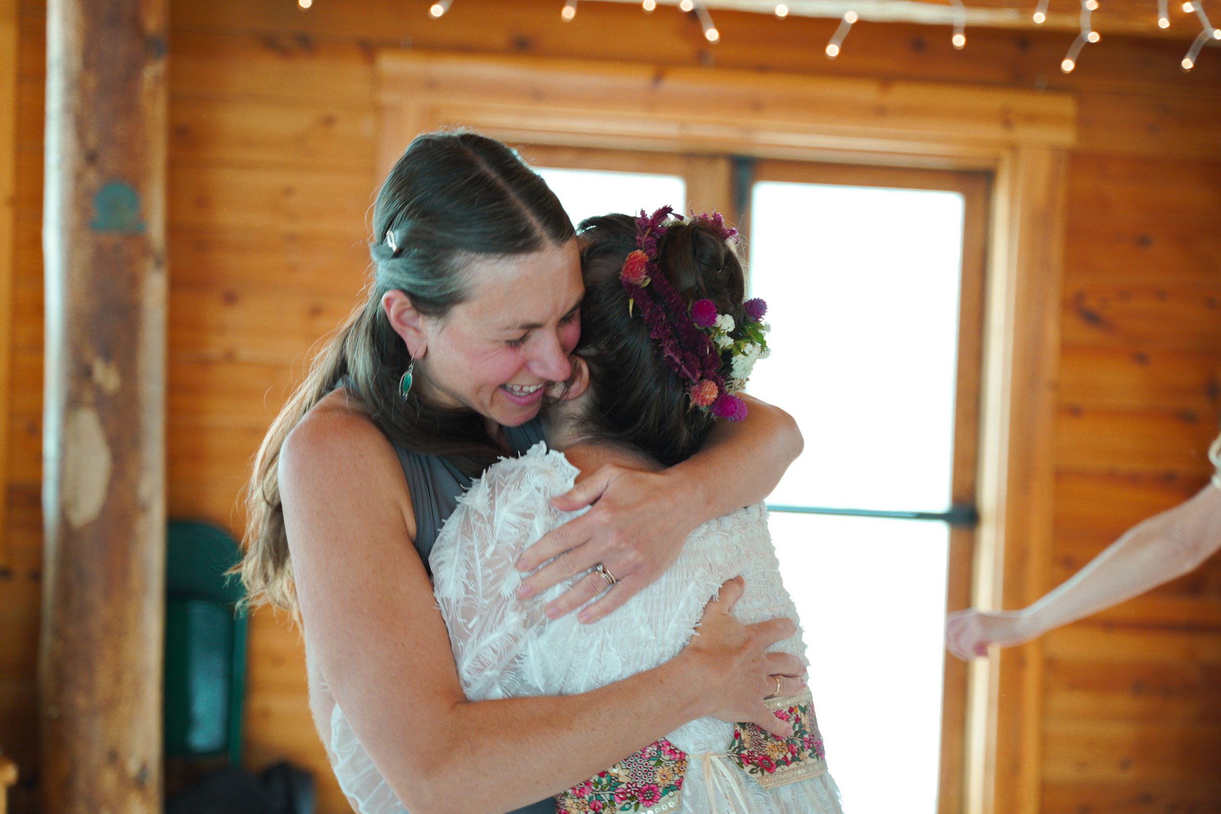 Intimate moment between a couple embracing during their wedding in a rustic wooden venue with natural light.