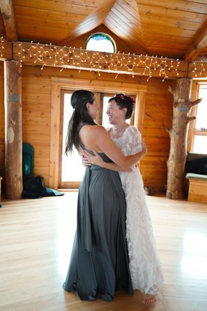 A couple dances together in a rustic wooden room decorated with twinkling string lights.