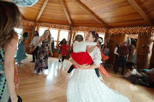 Dancing and celebration in a rustic wooden venue decorated with string lights.