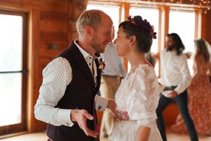A romantic dance between a couple at their wedding in a rustic venue with brick walls and wooden beams.