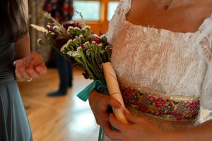 Close-up details of wedding attire and bouquets in soft teal and white colors.