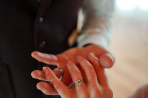 Close-up of hands showing off an engagement ring with sparkling diamond.