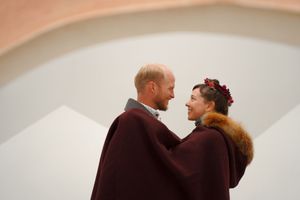 A winter wedding celebration with guests gathering in a warmly lit indoor space.