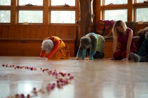 Rose petals scattered across a polished wooden floor during a wedding ceremony.
