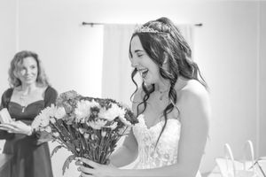 Black and white photo capturing a joyful moment with a bouquet.