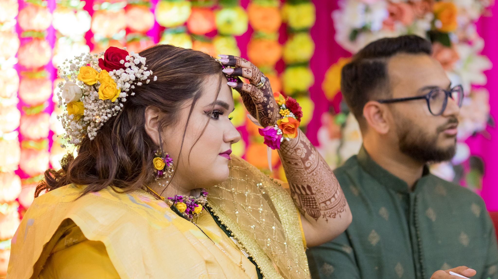 Traditional Indian bride wearing flower crown and golden attire during pre-wedding ceremony.