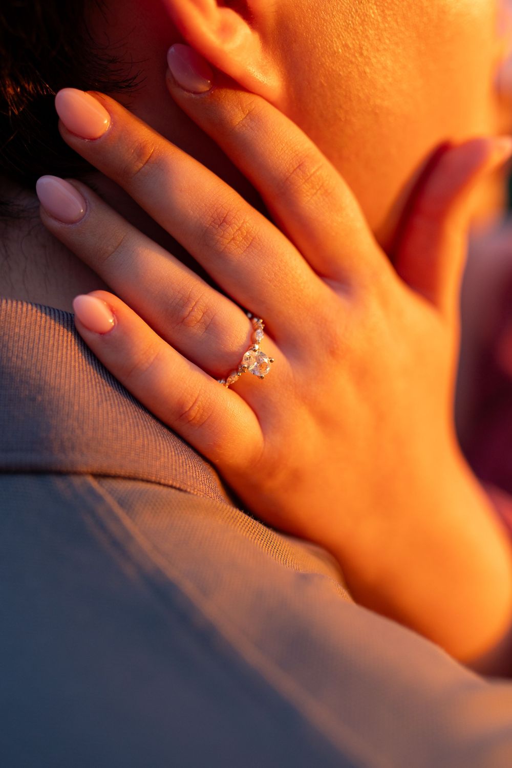 Close-up of engagement ring glowing in warm sunset light.